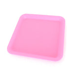 Silicone rolling tray in pink, perfectly square.  Side view.