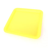 Silicone rolling tray in yellow, perfectly square. Side view.